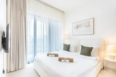 two beds in a hotel room with a window at Stylish Home with Direct Pool Access by the Canal in Dubai