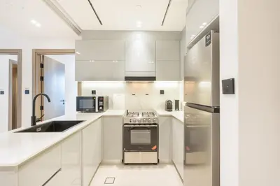 a kitchen with white cabinets and a stove top oven at Stylish Home with Direct Pool Access by the Canal in Dubai