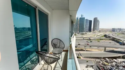 a balcony with two chairs and a view of a city at Dubai Marina - Cozy Studio Apartment in Dubai