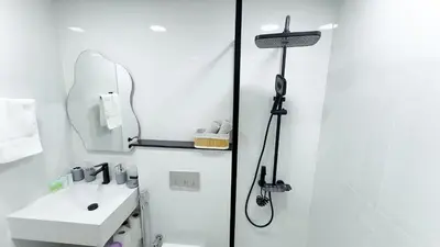 a white bathroom with a shower and a sink at Dubai Marina - Cozy Studio Apartment in Dubai
