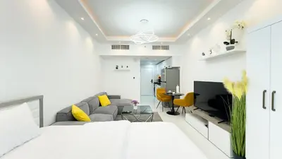 a living room with a couch and a tv at Dubai Marina - Cozy Studio Apartment in Dubai