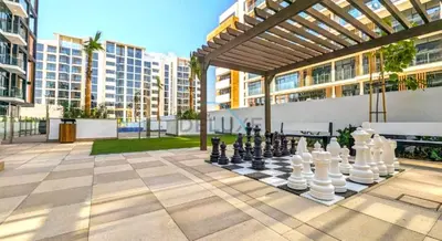a chess game on a chess board in a courtyard at Lovely Studio Apartment at Azizi Riviera 46 in Al Merkadh by Deluxe Holiday Homes in Dubai