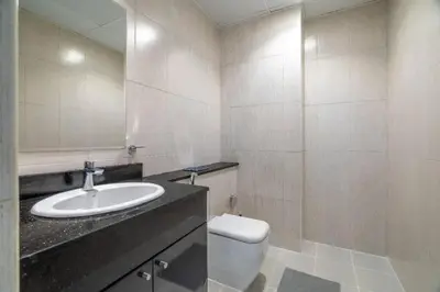 a bathroom with a sink and a toilet and a mirror at Exquisite 1Bedroom With City Views in Dubai