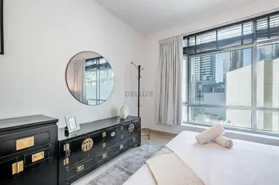 a bedroom with a black dresser and a mirror at Elegant 2BR in Park Island Bonaire, Dubai Marina by Deluxe Holiday Homes in Dubai