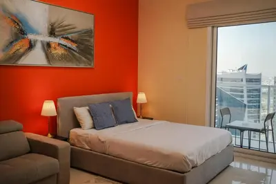 a bedroom with a bed and a couch and a window at Cozy studio in Business Bay Dubai in Dubai