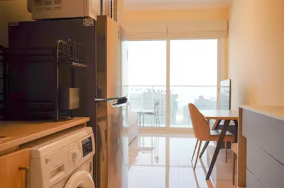 a kitchen with a refrigerator and a table with chairs at Cozy studio in Business Bay Dubai in Dubai