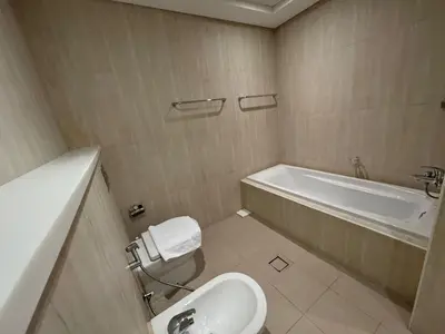 a bathroom with a tub and a toilet and a sink at Lovely 3BHK with private beach in Dubai