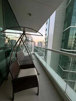 a swinging chair on a balcony in a building at Lovely 3BHK with private beach in Dubai