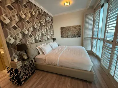 a bedroom with a bed in a room with windows at Lovely 3BHK with private beach in Dubai