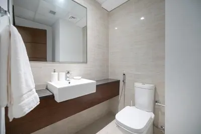 a bathroom with a white sink and a toilet at 2BR API 1000 Community View Jumeirah in Dubai
