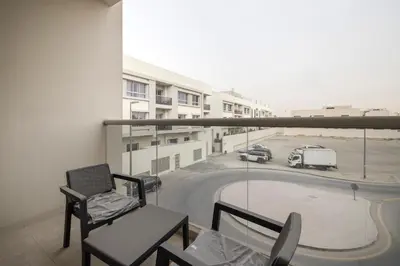 a balcony with a chair and a view of a parking lot at 2BR API 1000 Community View Jumeirah in Dubai