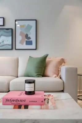 a living room with a couch and a candle on a table at 2BR API 1000 Community View Jumeirah in Dubai