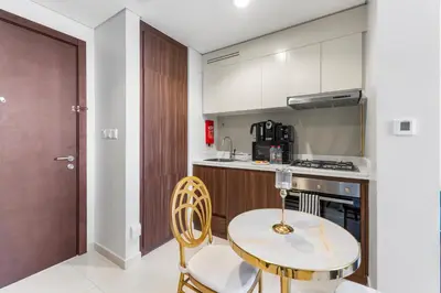 a kitchen with a table and chairs and a stove at Exclusive Burj Khalifa View - Modern 1 BR in Dubai