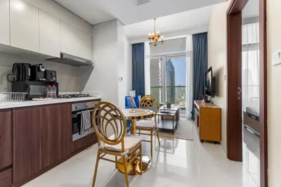 a kitchen and dining room with a table and chairs at Exclusive Burj Khalifa View - Modern 1 BR in Dubai