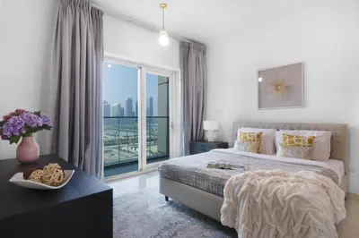 a bedroom with a bed and a large window at The Smart Concierge - Damac Heights in Dubai