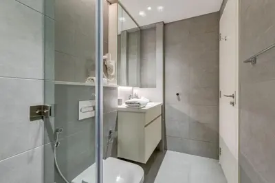 a bathroom with a shower and a toilet and a sink at Knokey Ahad Residence in Dubai