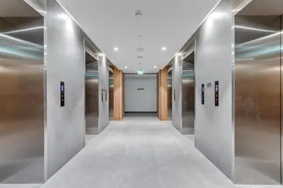 a hallway with silver elevator doors in a building at Knokey Ahad Residence in Dubai