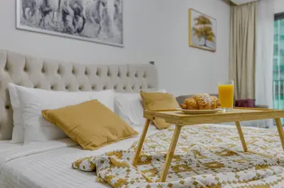 a bed with a table with a tray of food on it at Knokey Ahad Residence in Dubai