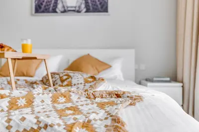 a bed with a comforter and a night stand on it at Knokey Aykon City in Dubai