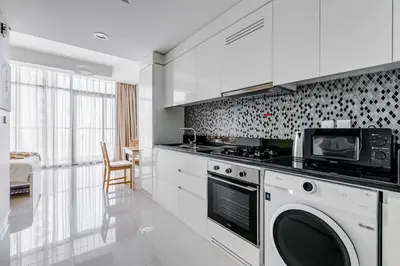 a kitchen with a stove and a microwave at Knokey Aykon City in Dubai