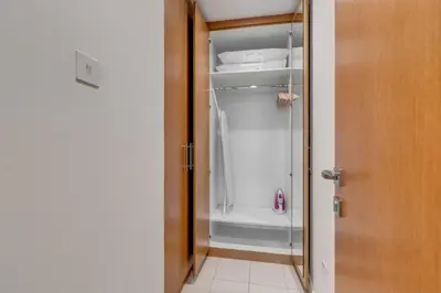 a closet with a glass door and a white refrigerator at Knokey Bay Square in Dubai