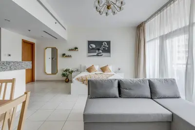 a living room with a couch in front of a bed at Knokey Bay Square in Dubai