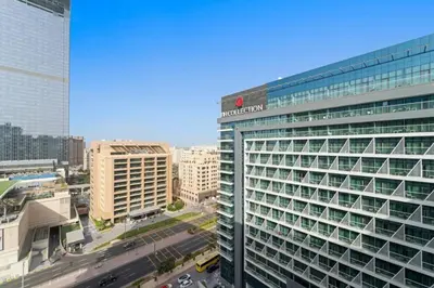 a tall building with a sign on it in a city at Chic Living 1 BHK with Beach Access in Dubai