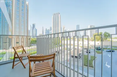 a balcony with two chairs and a view of a city at Downtown Views Tower 2 brand new apt in Dubai