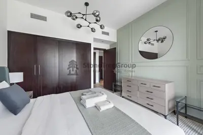 a bedroom with a large white bed and a mirror at Stylish 1 Br In Unique Location in Dubai