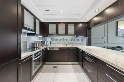 a kitchen with brown cabinets and a counter top at Stylish 1 Br In Unique Location in Dubai