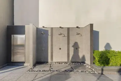 a stone wall with a shower in a building at Waves - Fully Equipped Studio for a Perfect Stay in Dubai in Dubai
