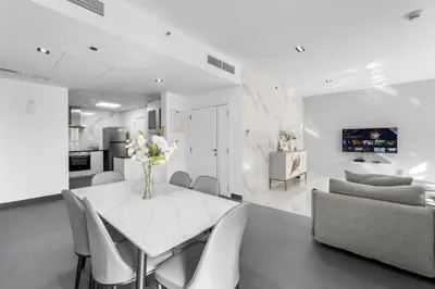 a white dining room with a white table and chairs at Sea View apt in JBR - 2 BR in front of the beach in Dubai