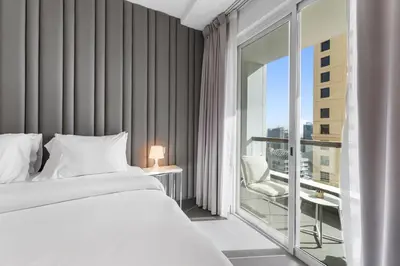a bedroom with a bed and a large window at Sea View apt in JBR - 2 BR in front of the beach in Dubai