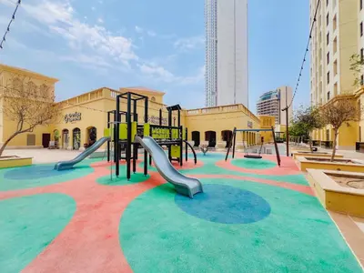 a playground with a slide in a park at Sea View apt in JBR - 2 BR in front of the beach in Dubai