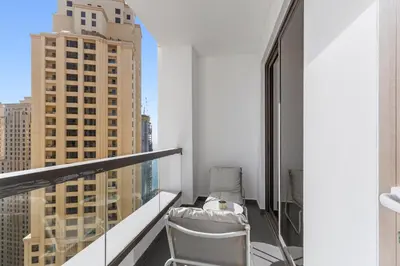 a balcony with a chair and a view of a city at Sea View apt in JBR - 2 BR in front of the beach in Dubai