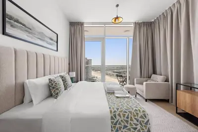 a bedroom with a bed and a couch and a window at Unique 1 BHK Near To Metro in Dubai