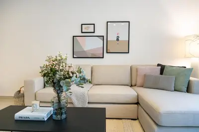 a living room with a couch and a table at 2BR API 1000 Community View Jumeirah in Dubai