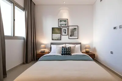a bedroom with a large bed with two lamps at 2BR API 1000 Community View Jumeirah in Dubai