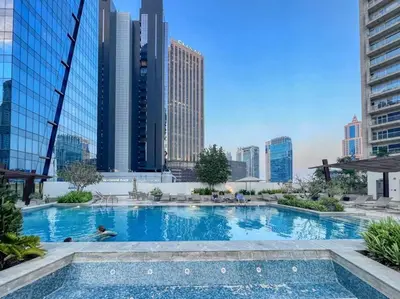 a large swimming pool in a city with tall buildings at The Smart Concierge - Silverene in Dubai