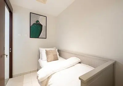 two beds in a room with white walls at Coastal Marina Escape - 4 BR Sea, Dubai Eye & Palm View in Dubai