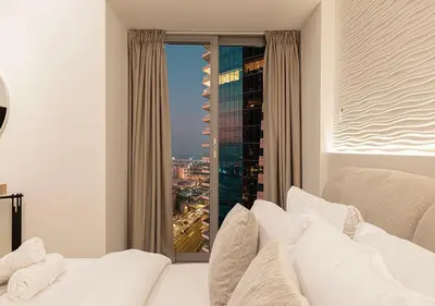 a bedroom with a white bed and a large window at Coastal Marina Escape - 4 BR Sea, Dubai Eye & Palm View in Dubai
