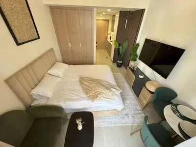 a bedroom with a bed and a couch and a television at Chic and Cozy Studio in Dubai