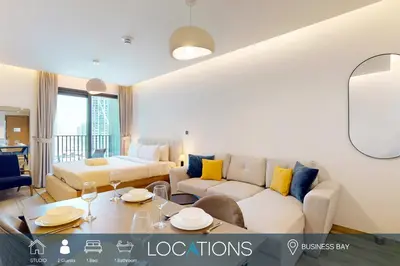 a living room with a couch and a table at Locations I Ahad Residences I Luxurious Studio Apartment I Business Bay I 10-Min Drive to Downtown Dubai & Burj Khalifa in Dubai