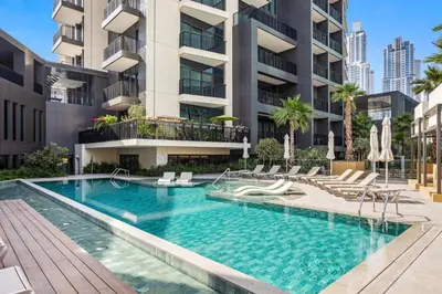 a swimming pool with chairs and a building at Locations I Ahad Residences I Luxurious Studio Apartment I Business Bay I 10-Min Drive to Downtown Dubai & Burj Khalifa in Dubai