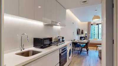 a kitchen with a sink and a stove top oven at Locations I Ahad Residences I Luxurious Studio Apartment I Business Bay I 10-Min Drive to Downtown Dubai & Burj Khalifa in Dubai