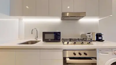 a kitchen with a sink and a stove top oven at Locations I Ahad Residences I Luxurious Studio Apartment I Business Bay I 10-Min Drive to Downtown Dubai & Burj Khalifa in Dubai