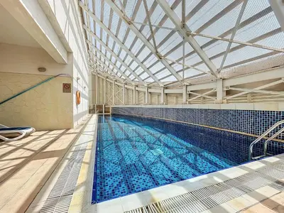 a large swimming pool with a large ceiling at The Bridge - Tranquil Two Bedroom in Sports City in Dubai