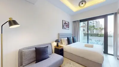 a bedroom with a bed and a couch at Azizi Riviera 9 - Bright Studio in Meydan in Dubai