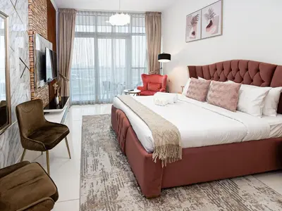 a bedroom with a large bed with a large window at Cozy and Stylish Studio Retreat in DAMAC Hills in Dubai