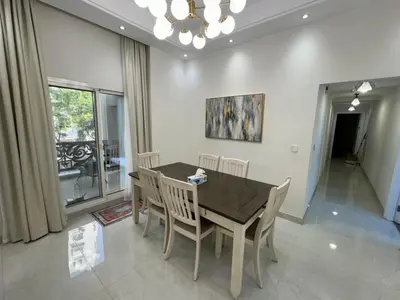 a dining room with a wooden table and chairs at Lovely Brand new 3 BR with maids room in Dubai
